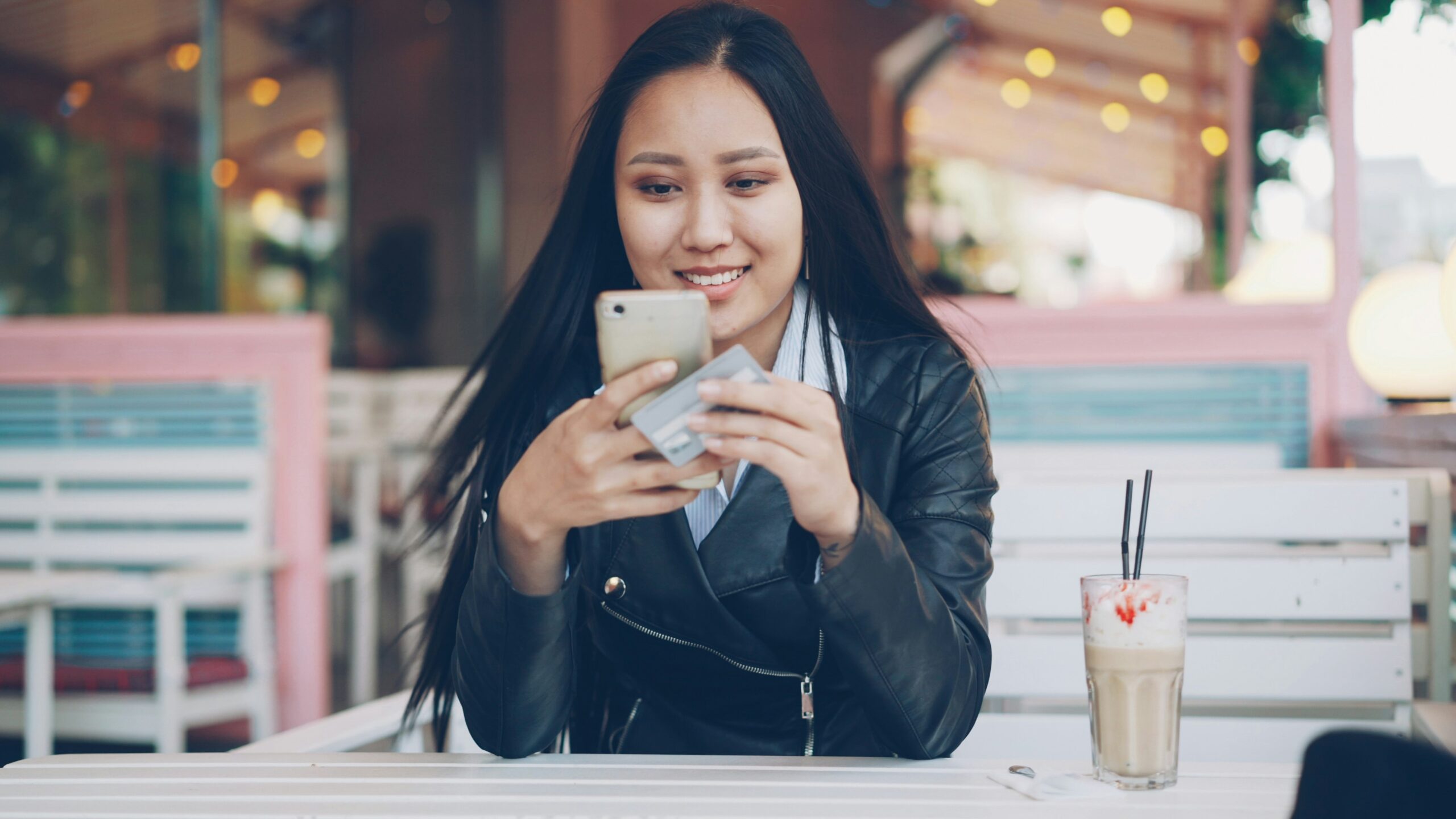 Woman using her smartphone to review financial options at an outdoor café